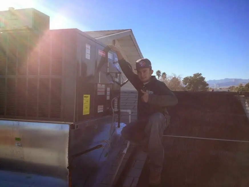 HVAC technician performing HVAC Inspection on a rooftop unit in Amelia